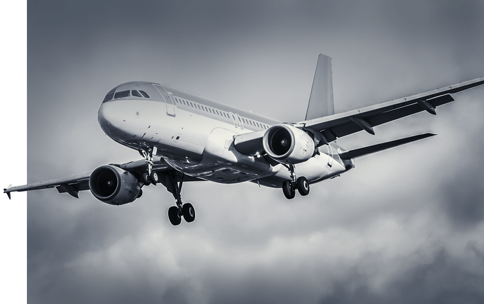 Ein Verkehrsflugzeug mit ausgefahrenem Fahrwerk fliegt durch einen bewölkten, grauen Himmel, von unten und leicht nach vorne betrachtet.